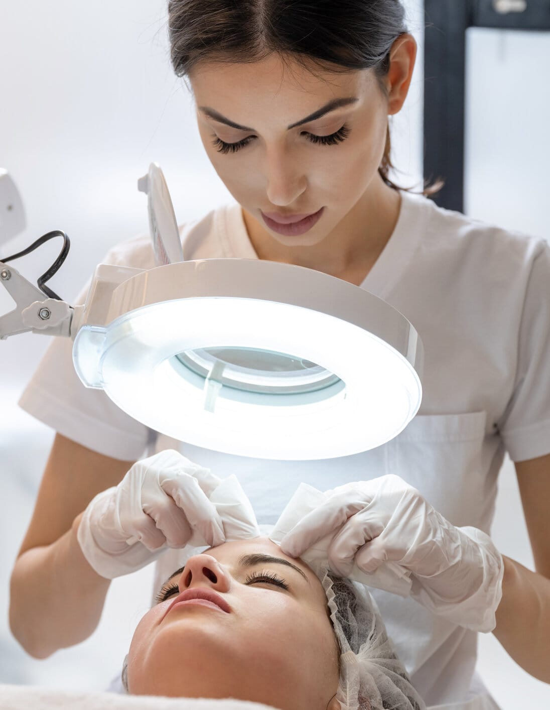 Skin treatment, beautician squeezing pimples from face of young female. Cleansing facial skin, beautician squeezed blackheads. facial